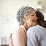 Shot of a senior woman hugging a young nurse in a retirement home