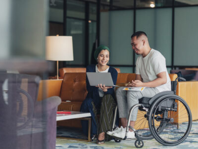 A female leader sharing insights with a disabled co worker