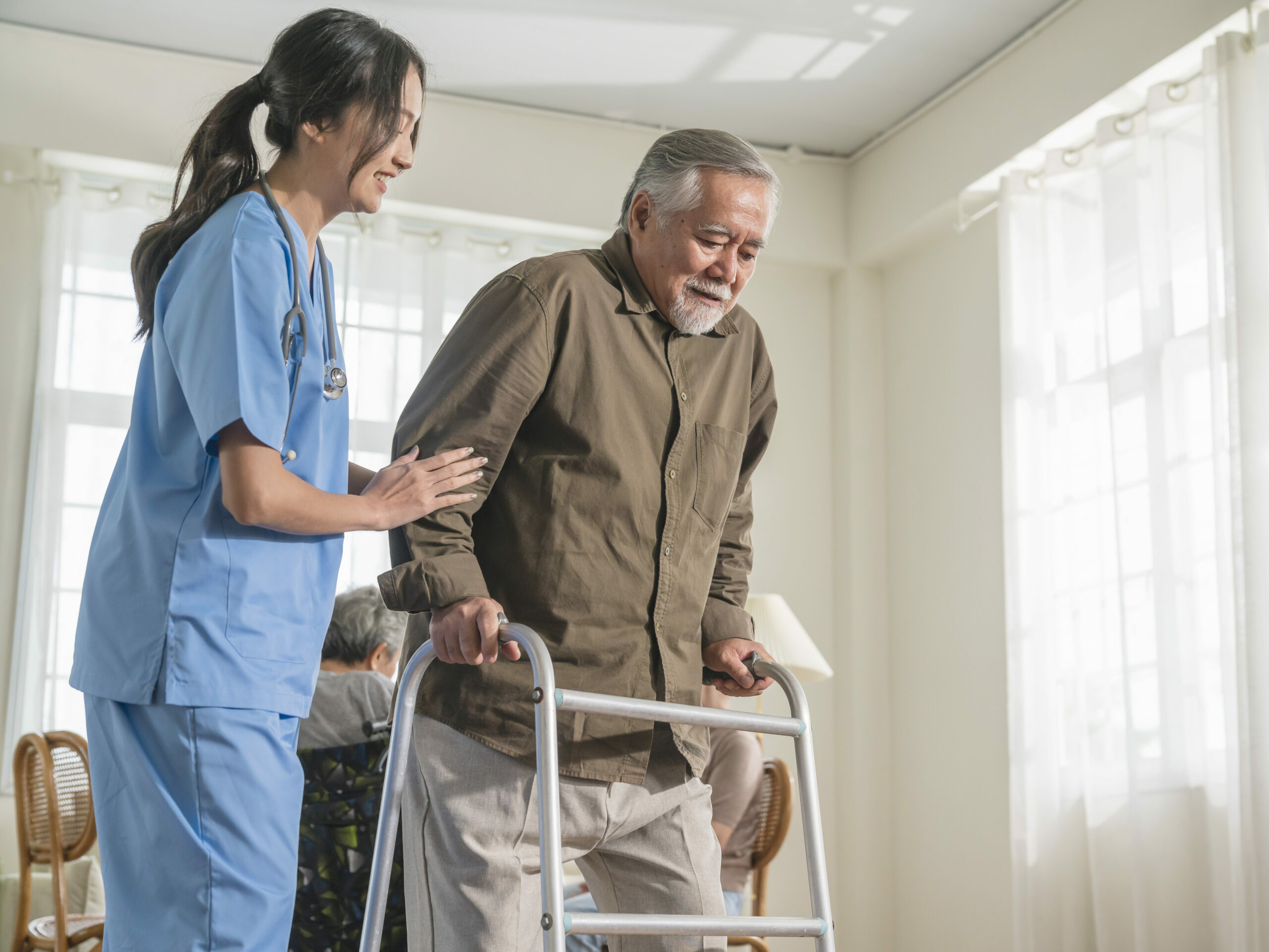 young asian female nurse care giver helping asian senior old man with mobility walker in living area of nursing home senior daycare center,Nurse take care elderly patient with cheerful concentrate