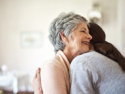 Shot of a senior woman hugging a young nurse in a retirement home