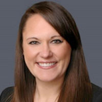 carolyn smiling into camera against gray background