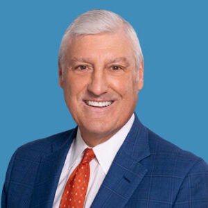 charles smiling into camera on blue background