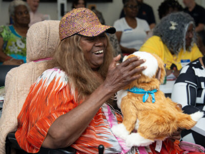 lady in wheelchair plays with robotic pet