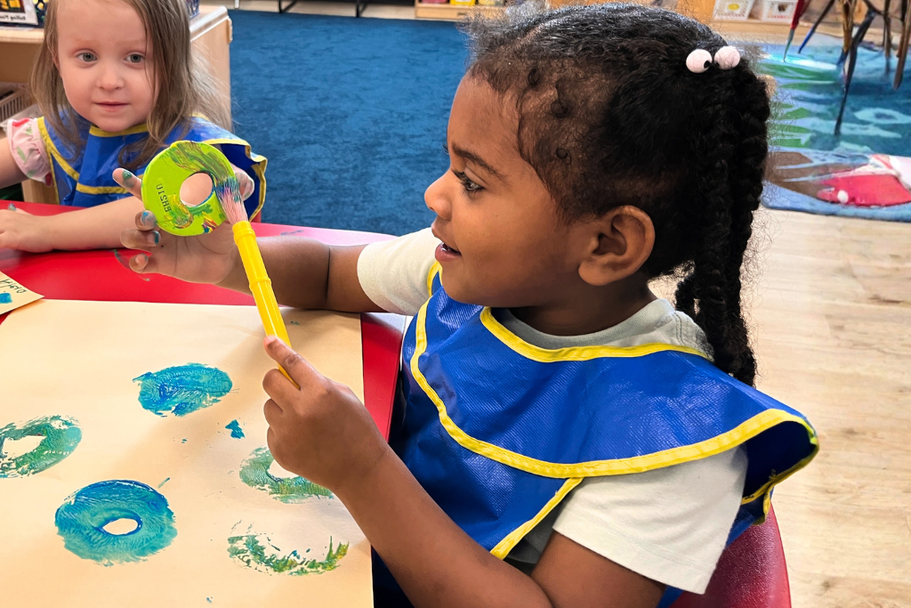 a little girl painting at school