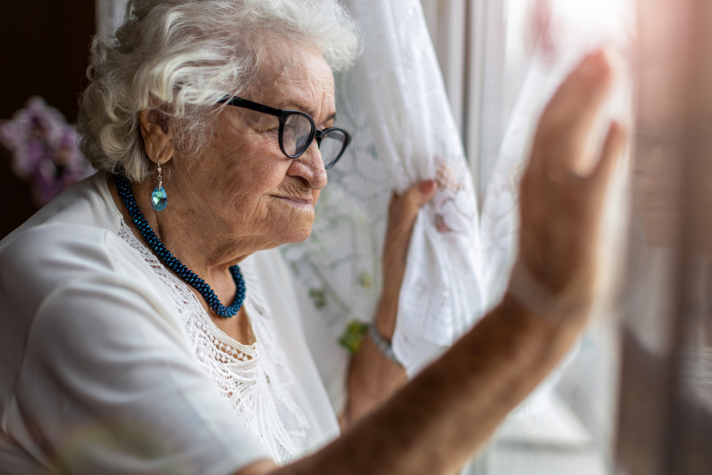 elderly woman looking out of the window